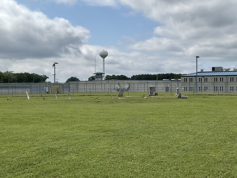 View of the fenced exterior and RCI building with its watchtower in the distance