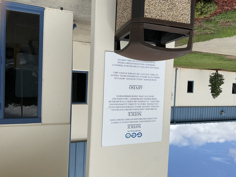 Notice located at the front entrance to RCI that reads: Law Enforcement Officers contact vehicle sallyport for firearms security instructions. No firearms, ammunition, destructivee device, weapons, narcotic drugs, controlled substances, ccell phones, tobacco, alcohol allowed beyond this point. All persons are subject to searches of their persons and property. Violations may result in a fine and/or imprisonment. [Repeated in Spanish]